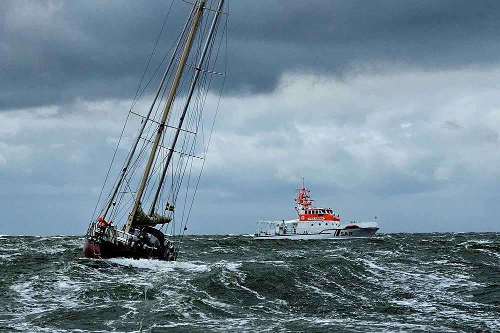 Die havarierte Yacht im Schlepp des Tochterbootes kurz vor Borkum, im Hintergrund Seenotrettungskreuzer „Theo Fischer“