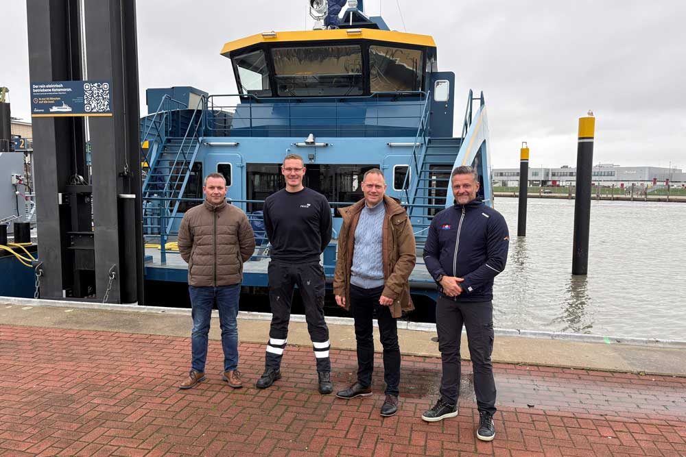 Vier Männer stehen vor einer Fähre