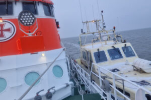 Der Seenotrettungskreuzer HERMANN RUDOLF MEYER (DGzRS-Station Bremerhaven) schleppt das havarierte Motorboot längsseits in den Hafen.