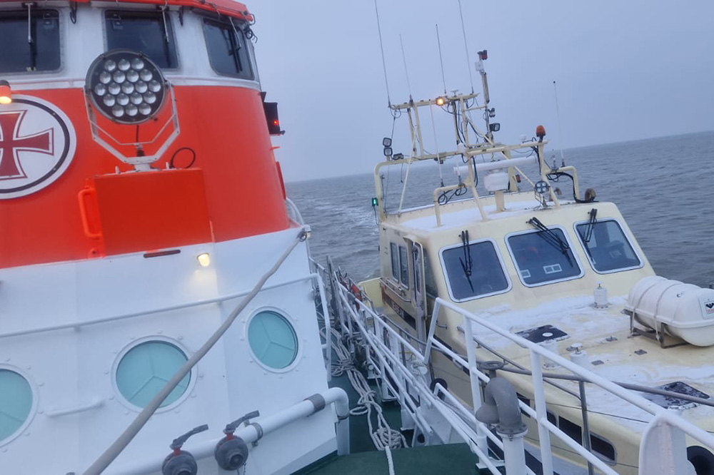 Der Seenotrettungskreuzer HERMANN RUDOLF MEYER (DGzRS-Station Bremerhaven) schleppt das havarierte Motorboot längsseits in den Hafen.