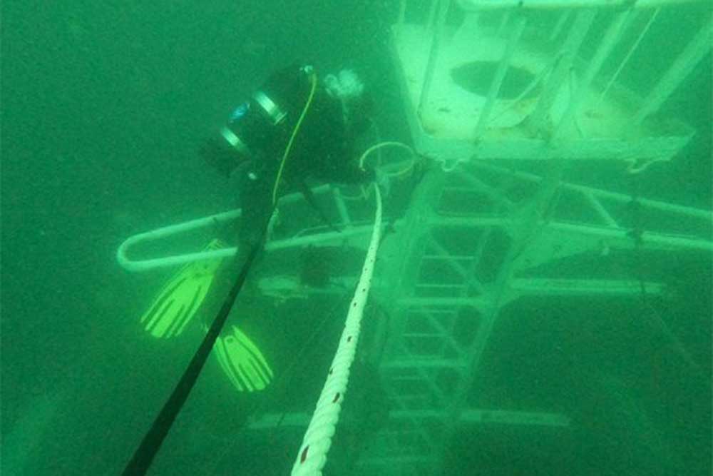 Ein Taucher befestigt eine Boje am Achtermast der gesunkenen „Sealloyd Arc“