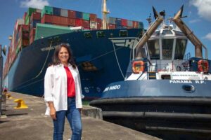 Ilya Espino de Marotta, Administratorin der Panama Canal Authority, vor einem Schlepper und einem Containerschiff