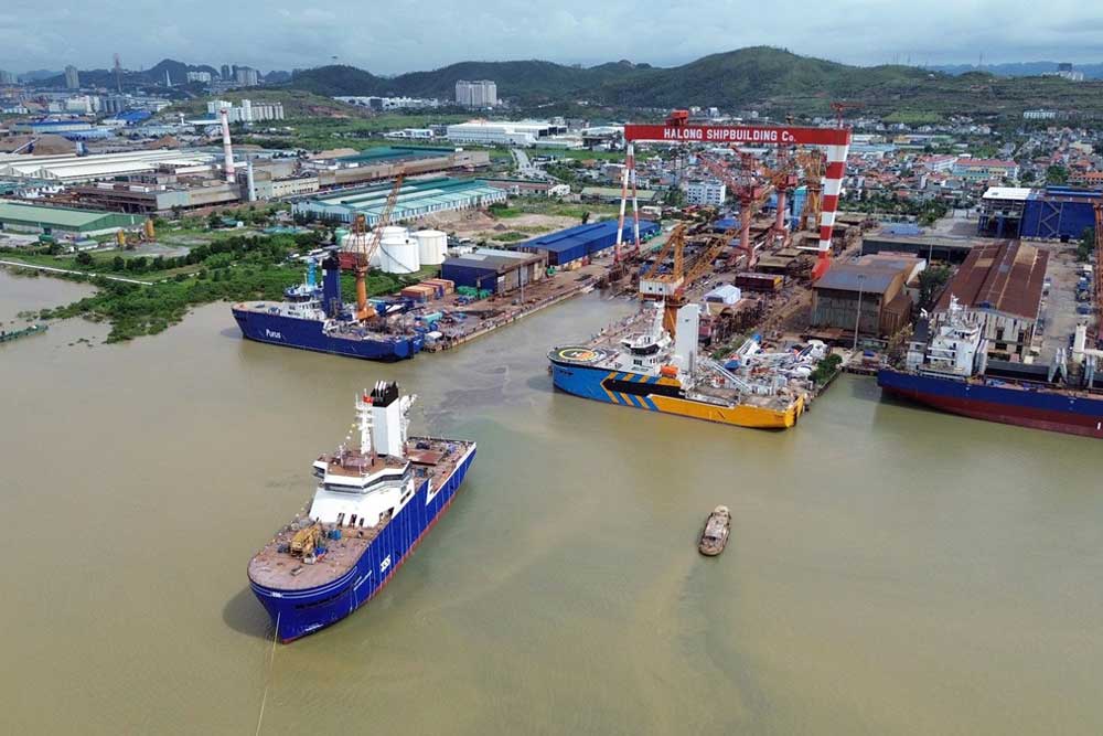 Blick auf ein Werftgelände in Vietnam; im Vordergrund ein Schiff, das die Werft verlässt