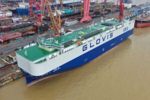 Car-Carrier „Glovis Nova“ in Shanghai, im Hintergrund ein Hafen