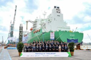 Taufe des LNG-Tankers „Halwan“; eine Menschengruppe vor einem grünen Tankschiff