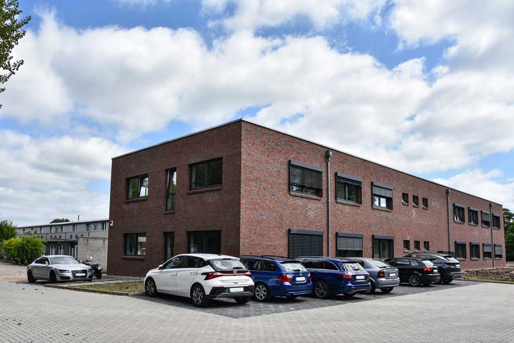 Bürogebäude, im Vordergrund einige Autos
