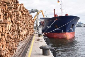 Schiff am Rostocker Fracht- und Fischereihafen, links im Bild Holzstapel an der Kaikante