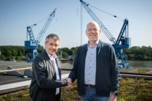 André Walter (l.) und Bernd Eikens auf dem Gelände der Meyer Werft, zwei Krane im Hintergrund
