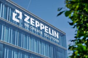 Bürogebäude vor blauem Himmel, Schriftzug: Zeppelin. We Create Solutions.