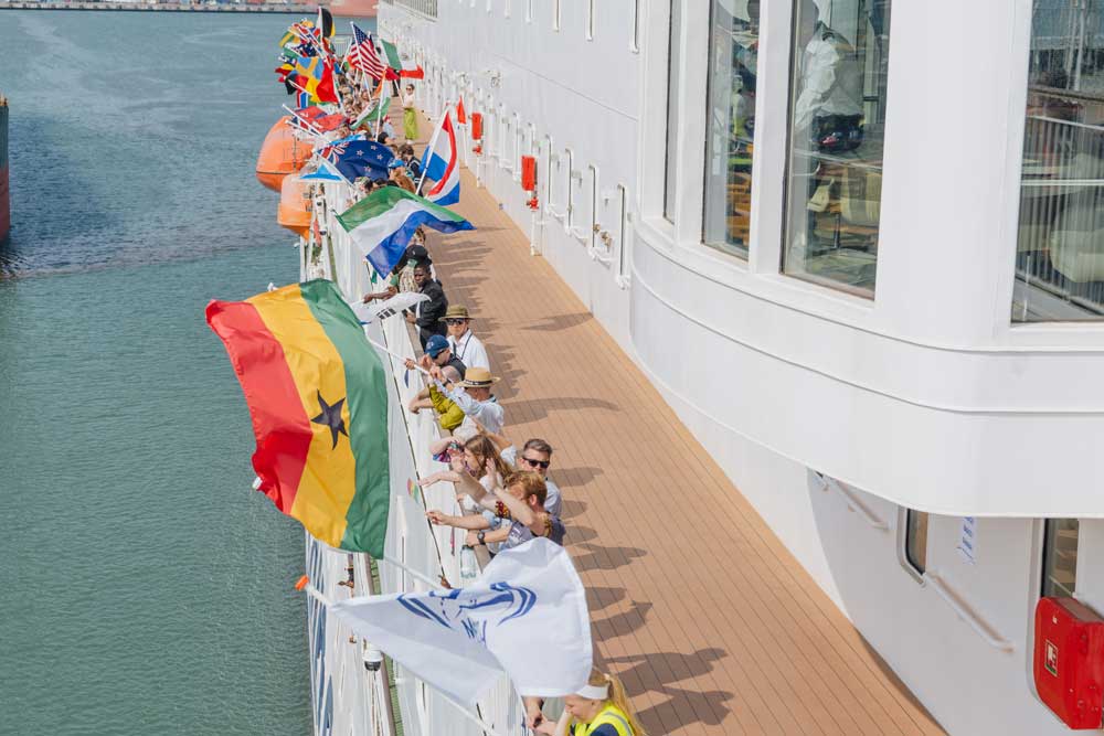 Menschen an Bord eines Schiffs, zu sehen ist die Flagge von Ghana