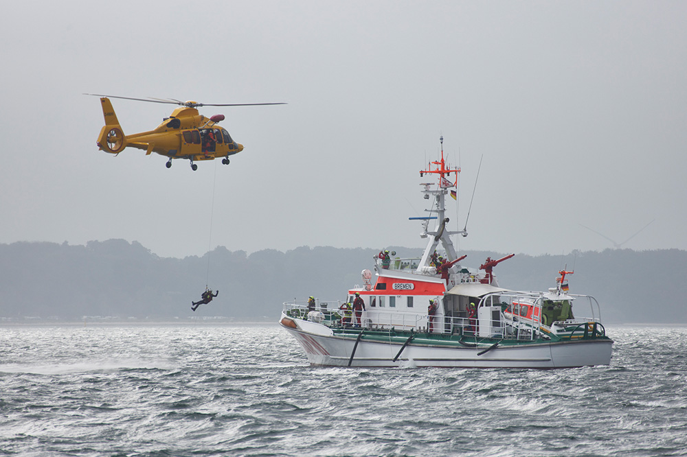 Erfolgreiche Such- und Rettungsübung in Eckernfoerder Bucht2.jpg: Ein Notarzt wird durch einen Rettungshubschrauber von NHC Northern Helicopter eingeflogen und per Seilwinde auf dem Seenotrettungskreuzer BREMEN abgesetzt. © Die Seenotretter - DGzRS / Peter Neumann