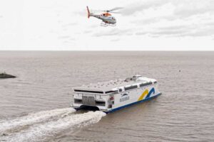 Elektrofähre „China Zorilla“, darüber ein Hubschrauber
