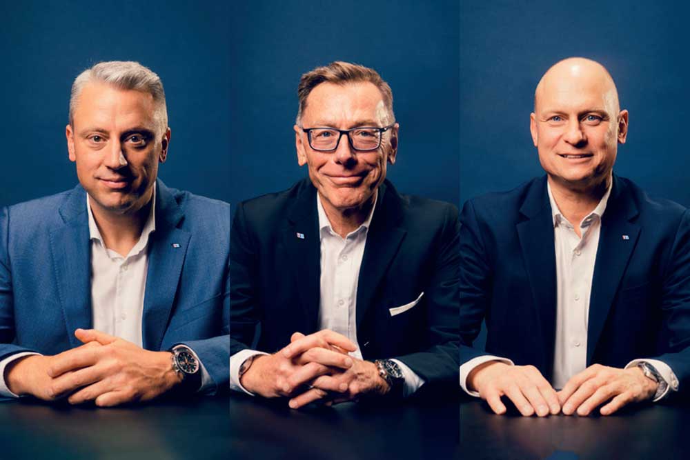 Drei Männer in Anzügen an einem Tisch